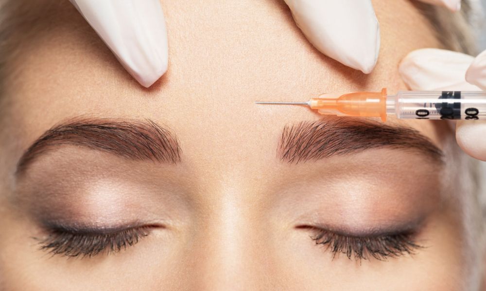 Woman getting botox injected into her forehead