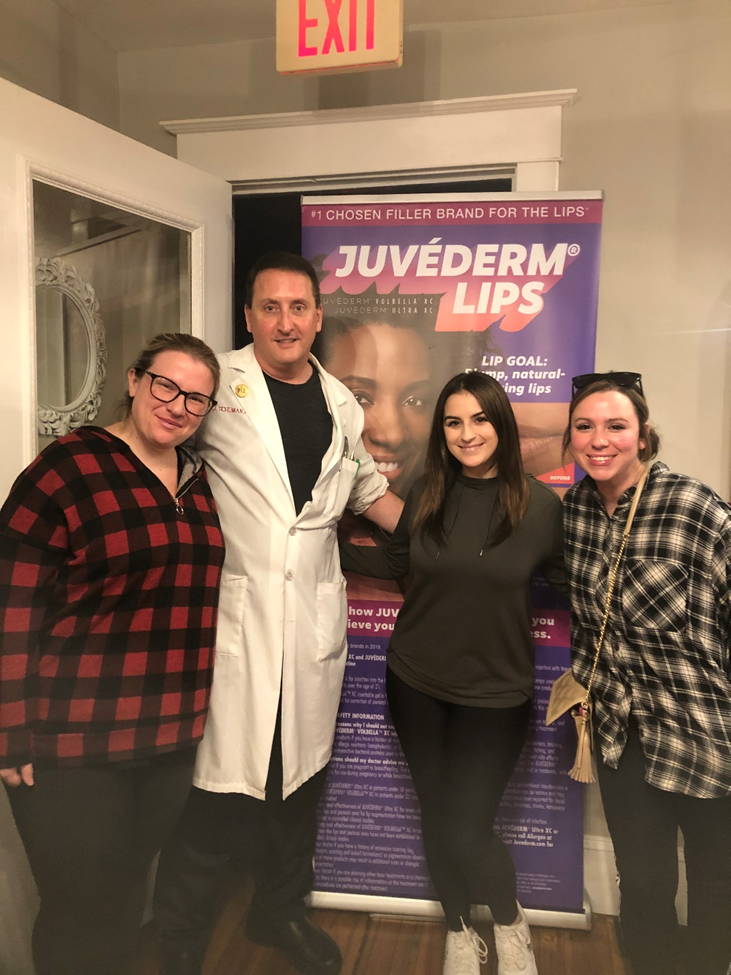Peter Schuman, PA-C and clients in front of Juvederm Lips poster(Picture 1)